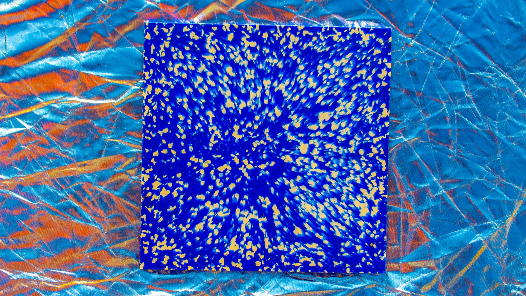 Placa Rewave azul com fragmentos amarelos sobre fundo natural azul e laranja